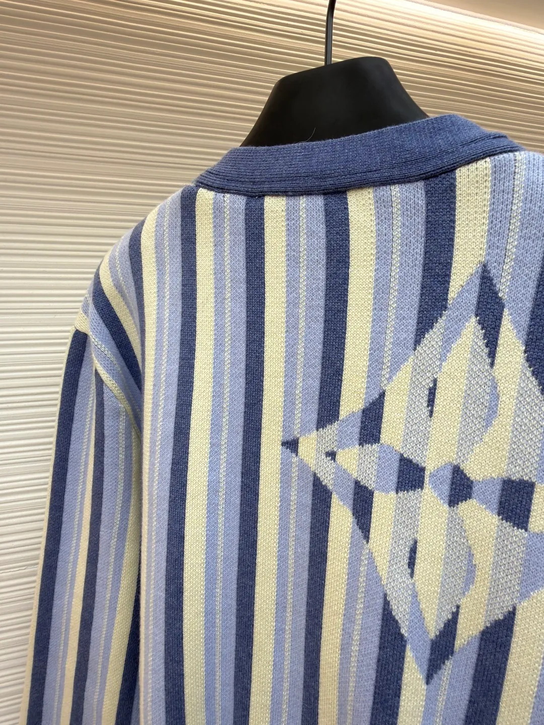 LOUIS VUITTON striped jacquard single-breasted sweater ●Original version: Purchased and developed for 15100 ●Item number: 1682314-C00 ●Fabric: wool fabric ●Technology: jacquard knitting ●Color: blue ●Version: fitted version ●Weight: about 930 grams ●Size: S-M-L-XL ●Description: This LV striped knitted cardigan is made of high-count worsted wool blended yarn. The double-ply threading process enhances the yarn's toughness. It is not easy to pill and has an outstanding drape feeling. The body of the garment adopts vertical jacquard weaving technology, with navy blue, light blue and off-white yarns interlaced with each other. The stripe width and spacing are precisely controlled by a computerized flat knitting machine, so that the color transition is natural and even. The LV letter jacquard on the left body has been debugged several times through plate making to ensure that the pattern is three-dimensional and clear. The V-neck, cuffs, and hem all use ribbing technology and are pre-shrunk to shape, making them less likely to loosen and deform after long-term wear. The buttons are made of custom-made metal, with matte sandblasting on the surface, and are hand-stitched with the seams of the body. The pockets use welting technology, and the edges are flat without jumpers. Every detail reflects the exquisite clothing craftsmanship and brand ingenuity. The overall wiring is straight and delicate, the fabric is comfortable and soft, and the color is consistent without color difference. It can be matched with the same style to create a fashionable look and control various occasions. Customized accessories, complete with three standards, same style for men and women!